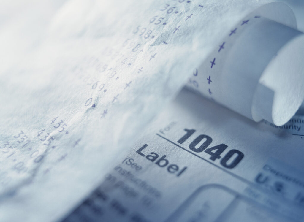 Calculator tape over 1040 tax form